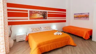 a bedroom with two beds with orange sheets and a flag at White in Castellammare del Golfo