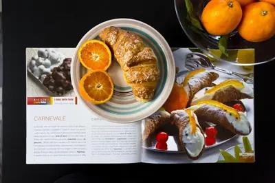 a magazine with a plate of food with oranges and cookies at Bilocale in Centro in Palermo