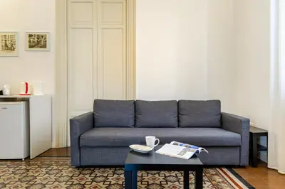 a living room with a blue couch and a coffee table at Bilocale in Centro in Palermo