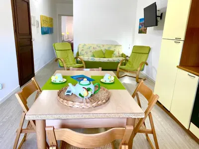 a kitchen and living room with a table and chairs at Residence Le Rose in Castellammare del Golfo