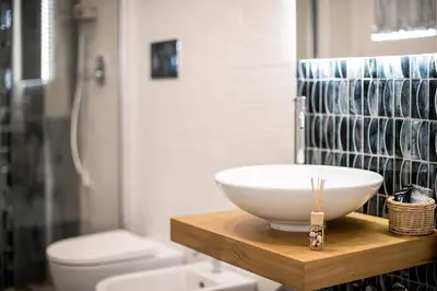 a bathroom with a bowl sink and a toilet at Il Mare Dentro Rooms in San Vito lo Capo