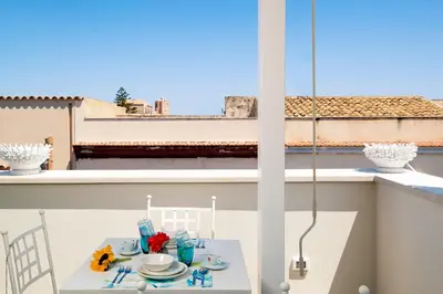 a small table on a balcony with a view at Il Mare Dentro Rooms in San Vito lo Capo