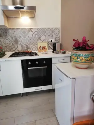 a kitchen with a stove and a vase on the counter at Appartamenti La Stella in Castellammare del Golfo