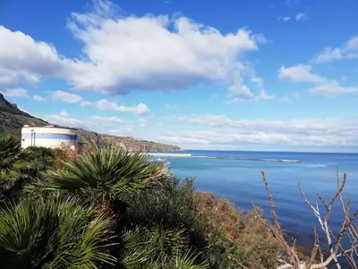 a view of the ocean from a hill with trees at Appartamenti La Stella in Castellammare del Golfo