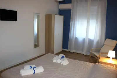 a bedroom with a bed with towels and a chair at Zammù in Palermo