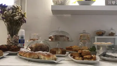 a table with plates of pastries and other pastries at Cima Bianca in San Vito lo Capo