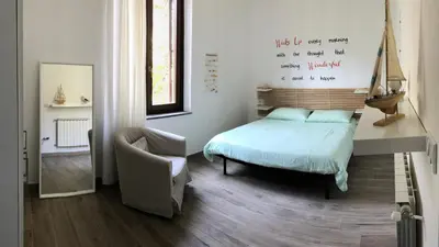 a bedroom with a bed and a chair in it at A un passo dal mare in Lido di Mondello