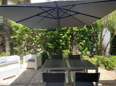 a table and chairs with an umbrella on a patio at A un passo dal mare in Lido di Mondello
