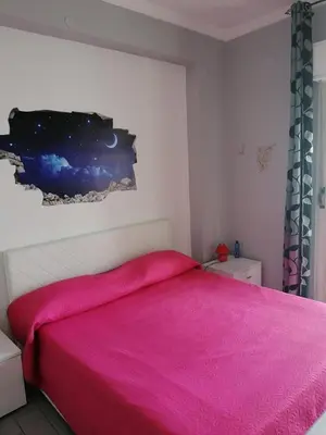 a bedroom with a bed with a pink blanket at Casa Normanna in Monreale