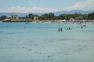 a group of people in the water at a beach at Nonna Anna Rooms in Palermo