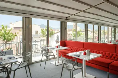 a restaurant with a red couch and tables and chairs at Hotel Porta Felice & Spa in Palermo