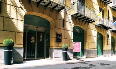 a building with two potted plants in front of it at Hotel Porta Felice & Spa in Palermo