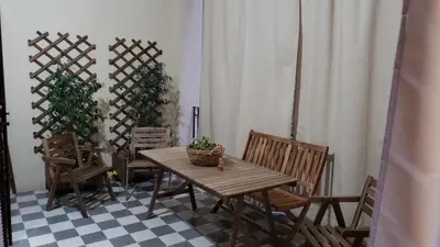 a wooden table and chairs with a potted plant at Duchi in Palermo