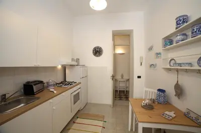 a kitchen with white cabinets and a sink and a table at Duchi in Palermo