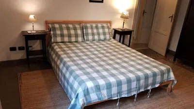 a bed with a blue and white checkered blanket and two tables at Duchi in Palermo