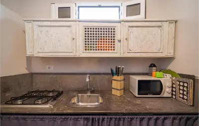 a kitchen counter with a sink and a microwave at Palermo Per Due in Torretta