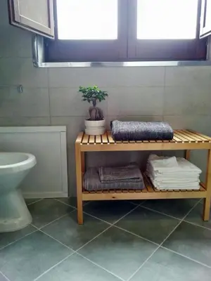 a bathroom with a shelf with towels and a toilet at Capo House in Palermo
