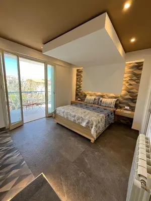 a bedroom with a large bed and a balcony at Mongibello Palace B&B in Mondello