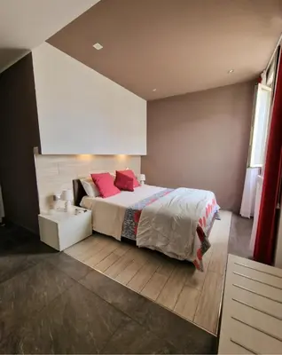 a bedroom with a large bed with red pillows at Mongibello Palace B&B in Mondello
