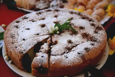 a cake with powdered sugar on top on a plate at B&B La Chiocciola in Castelluzzo