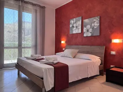 a bedroom with a large bed with red walls at B&B La Chiocciola in Castelluzzo