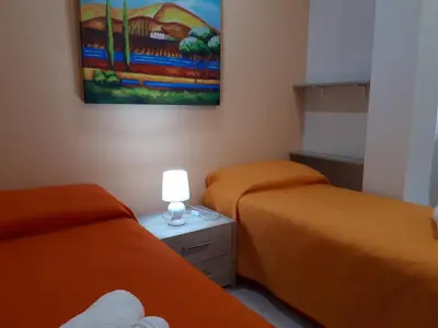 a room with two beds and a painting on the wall at Casa Vacanza Demi in Alcamo Marina