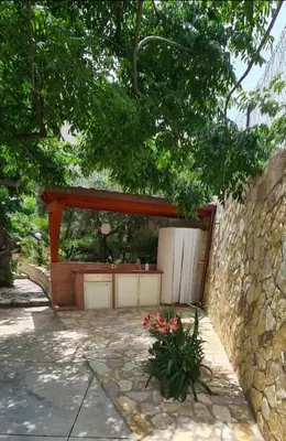 a stone wall with a pavilion in a garden at Casa Vacanza Demi in Alcamo Marina