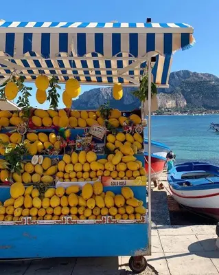 a bunch of oranges on a stand in front of the ocean at Matilde Boutique Hotel by AR Group Hotels in Isola delle Femmine