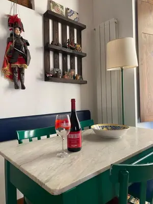 a bottle of wine sitting on a table with a glass at 3Sisters Apartments in Palermo