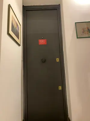 a black door with a sign on it in a room at 3Sisters Apartments in Palermo