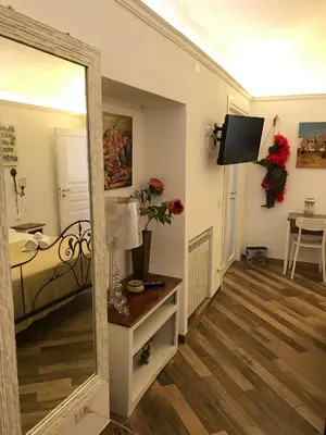a mirror in a room with a bed and a table at Ballarò Holiday in Palermo
