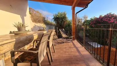 a patio with chairs and a fence and flowers at Villa Margherita in Terrasini