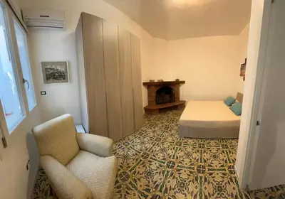 a bedroom with a bed and a couch and a chair at Villa Margherita in Terrasini
