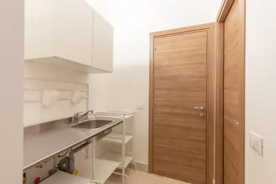 a kitchen with a sink and a wooden door at Sant'Agostino Apartment by DomuSicily in Palermo