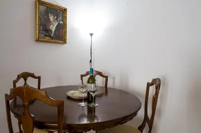 a table with a bottle of wine and two glasses on it at Sant'Agostino Apartment by DomuSicily in Palermo