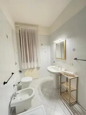 a white bathroom with a toilet and a sink at Villa sul mare Palazzolo in Trappeto