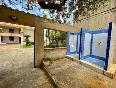 a bathroom with blue tile on the side of a building at Villa sul mare Palazzolo in Trappeto