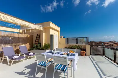 a patio with a table and chairs on a balcony at Casa Colibrì - Solemar Sicilia in Santa Flavia