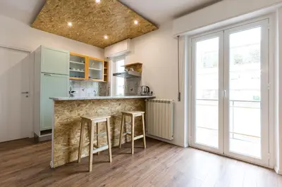 a kitchen with a counter and stools in a room at Casa Colibrì - Solemar Sicilia in Santa Flavia