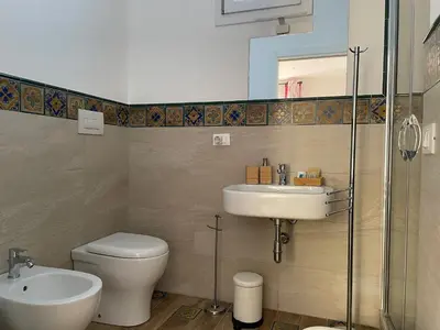 a bathroom with a toilet and a sink and a shower at Suite de la Sicilienne in Castellammare del Golfo