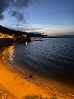 a view of a beach at night with the ocean at Suite de la Sicilienne in Castellammare del Golfo