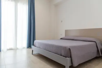 a bedroom with a bed with a purple blanket at B&B Vista Mare in San Vito lo Capo