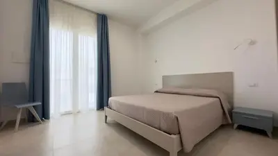 a bedroom with a bed and a large window at B&B Vista Mare in San Vito lo Capo