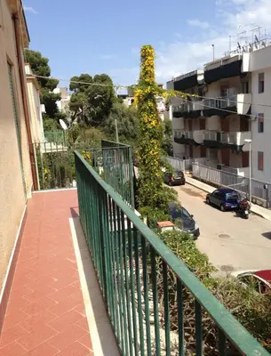 a balcony with a green fence and a tree at Holiday mondello in Mondello
