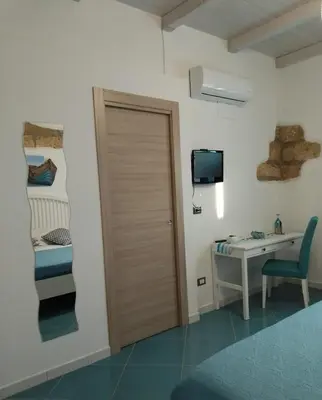 a room with a door and a desk and a bed at Ca&Sa Sweet Holiday in Cinisi