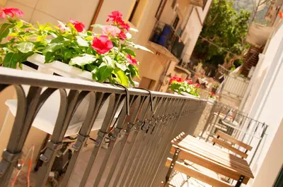 a balcony with a bench and flowers on it at B&B Nencioli in Castellammare del Golfo