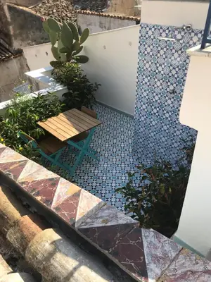 a patio with a mosaic floor and a bench at Charming loft con Terrazze al Teatro Massimo in Palermo