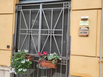 a building with green shutters and a wooden door at La casetta di Tilde in Termini Imerese