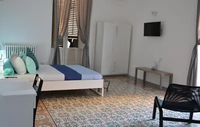 a bedroom with a bed and a table and a chair at Dietro al Massimo in Palermo