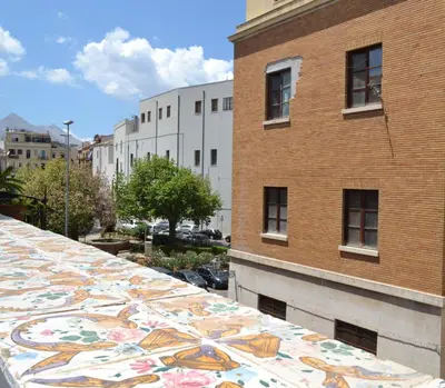 a building with a colorful tile roof in front of a building at Dietro al Massimo in Palermo